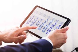 Close-up Of A Businessperson's Hand Using Calendar On Digital Tablet